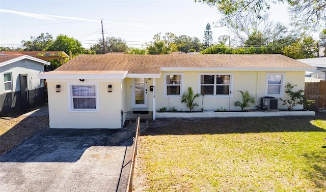 view of front of property with central AC and a front yard