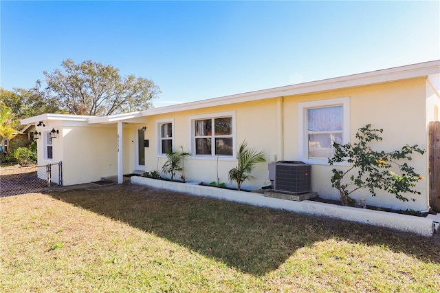 ranch-style home featuring central AC and a front yard