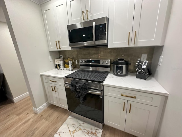 kitchen with light stone counters, white cabinetry, appliances with stainless steel finishes, and tasteful backsplash