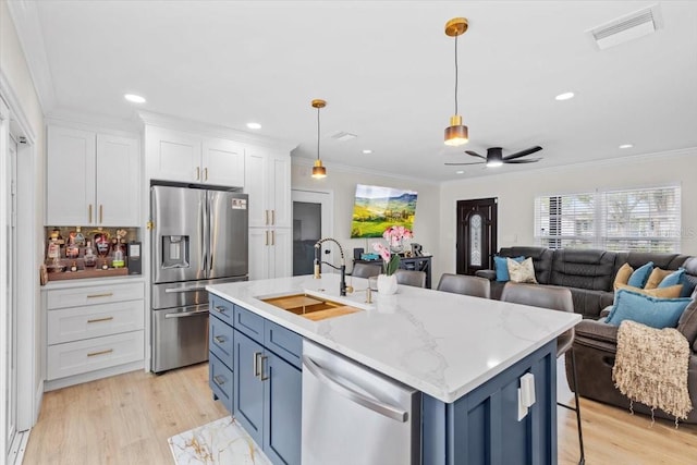 kitchen with white cabinetry, blue cabinetry, stainless steel appliances, and sink