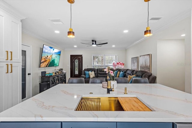 kitchen featuring light stone countertops, a kitchen island, and pendant lighting