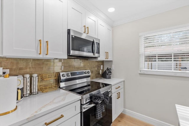 kitchen featuring crown molding, white cabinetry, backsplash, stainless steel appliances, and light stone counters