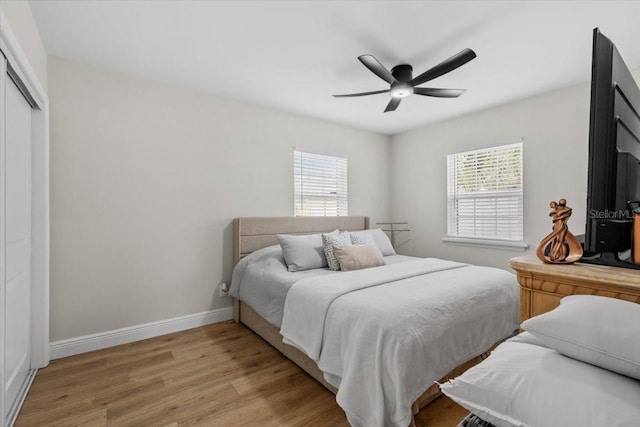 bedroom featuring ceiling fan, light hardwood / wood-style floors, and a closet