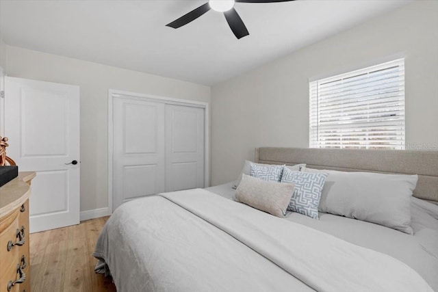 bedroom featuring ceiling fan, a closet, and light hardwood / wood-style flooring