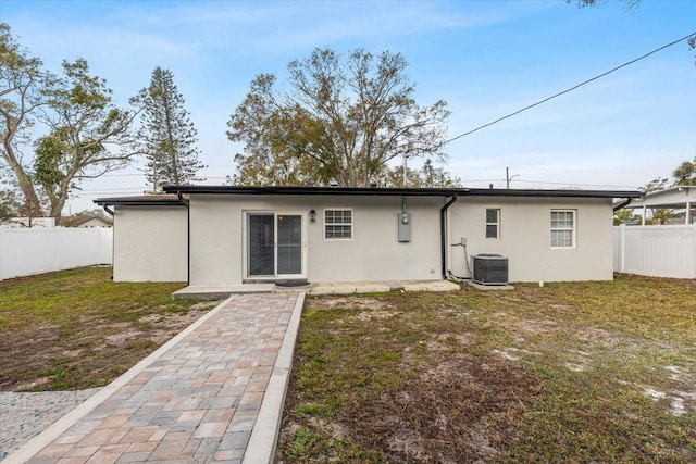 back of house featuring central AC and a yard