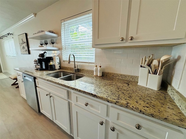 kitchen with light stone countertops, dishwasher, white cabinetry, decorative backsplash, and sink