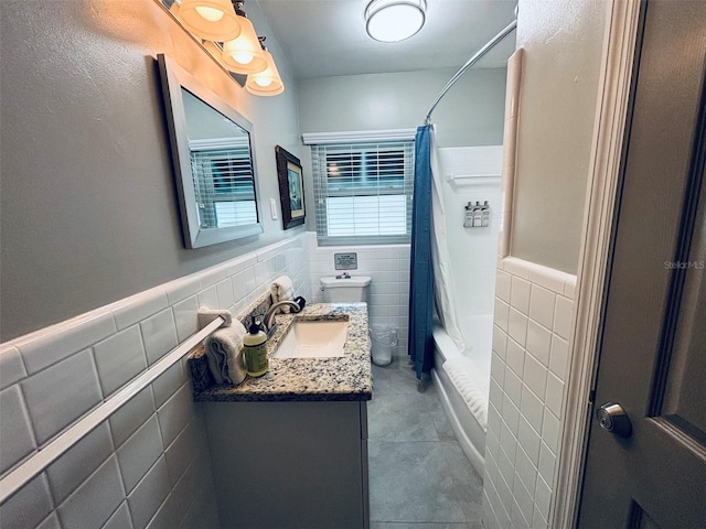 full bathroom with toilet, vanity, tile walls, tile patterned floors, and shower / bath combination with curtain