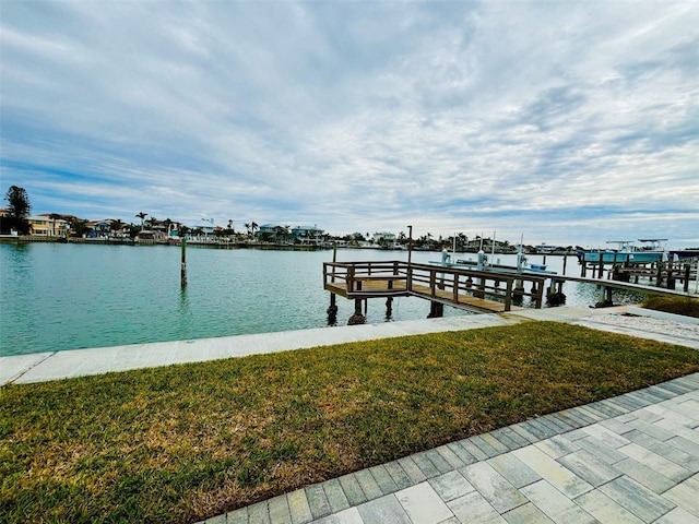 dock area featuring a water view and a lawn