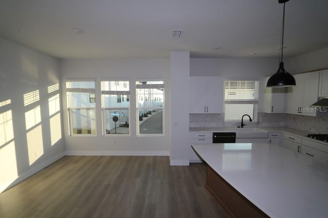 kitchen with a sink, plenty of natural light, white cabinets, and light countertops