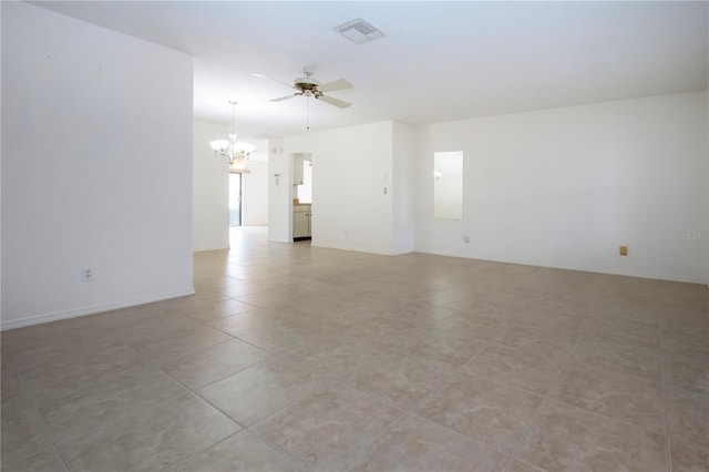 spare room with ceiling fan with notable chandelier and light tile patterned flooring