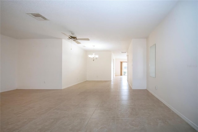 empty room with light tile patterned flooring, ceiling fan with notable chandelier, and a textured ceiling