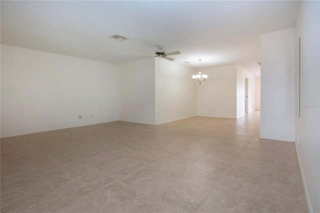 tiled empty room featuring ceiling fan with notable chandelier