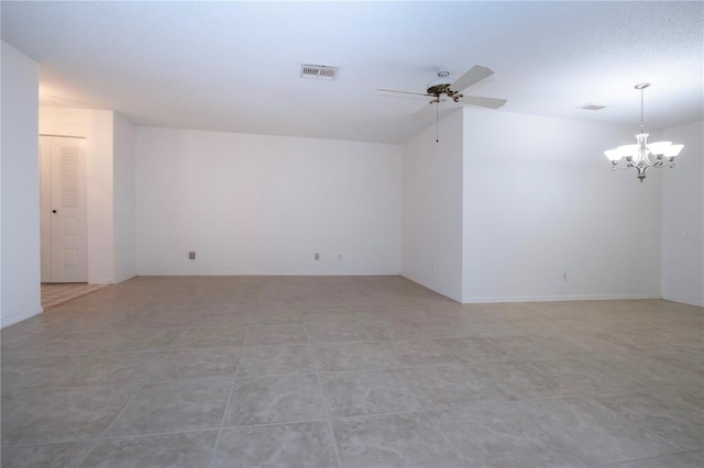 tiled empty room featuring a textured ceiling, lofted ceiling, and ceiling fan with notable chandelier