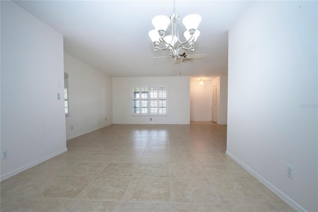 empty room with light tile patterned floors and a notable chandelier