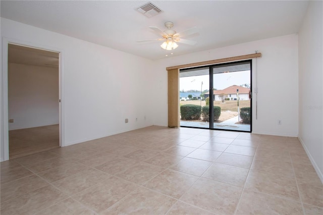 tiled spare room with ceiling fan