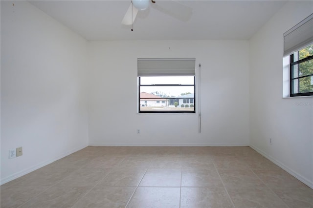 spare room with ceiling fan and light tile patterned floors