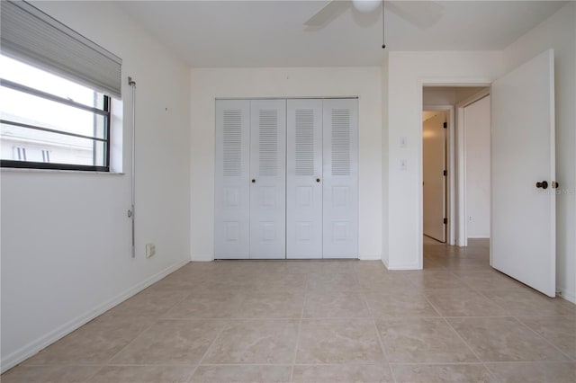 unfurnished bedroom with ceiling fan, a closet, and light tile patterned flooring