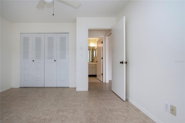 unfurnished bedroom with ceiling fan, light tile patterned floors, and a closet