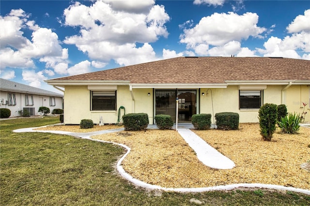 ranch-style house featuring central AC unit and a front lawn