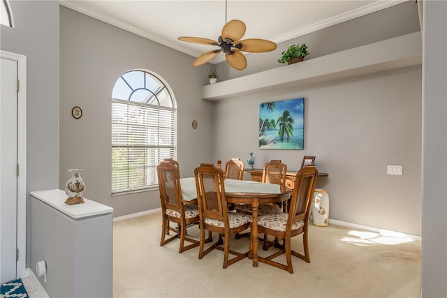 dining room with light carpet, crown molding, and ceiling fan