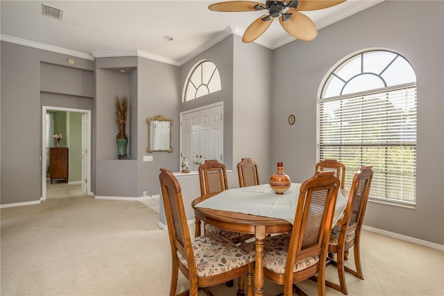 carpeted dining space with ornamental molding and ceiling fan