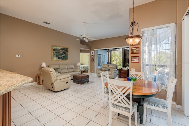 dining space with lofted ceiling, light tile patterned floors, and ceiling fan