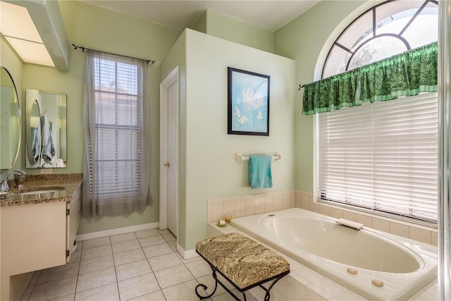 bathroom with vanity, tile patterned flooring, and tiled tub