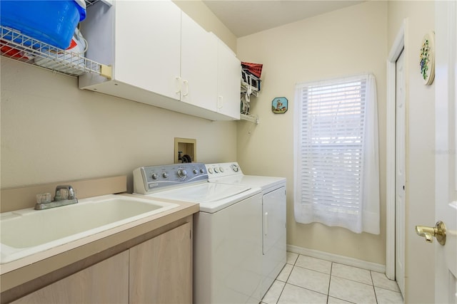 clothes washing area with cabinets, light tile patterned floors, sink, and washing machine and clothes dryer