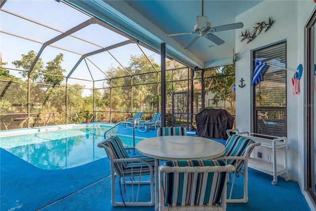 view of pool with grilling area, ceiling fan, glass enclosure, and a patio area