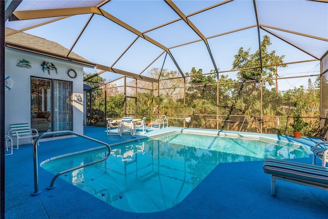 view of swimming pool featuring a patio and glass enclosure