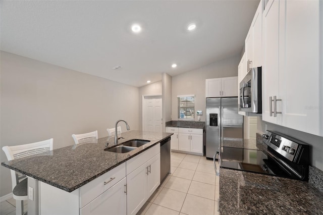 kitchen with sink, stainless steel appliances, an island with sink, and white cabinets