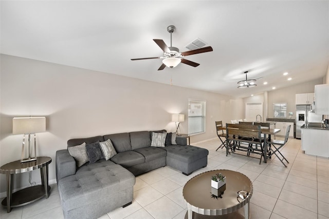 living room featuring lofted ceiling, light tile patterned floors, and ceiling fan