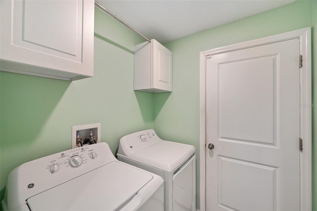 clothes washing area with independent washer and dryer and cabinets