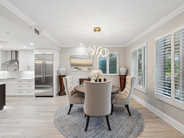 dining space with ornamental molding, a chandelier, and light wood-type flooring