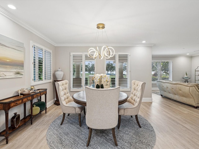 dining space featuring an inviting chandelier, crown molding, and light hardwood / wood-style floors