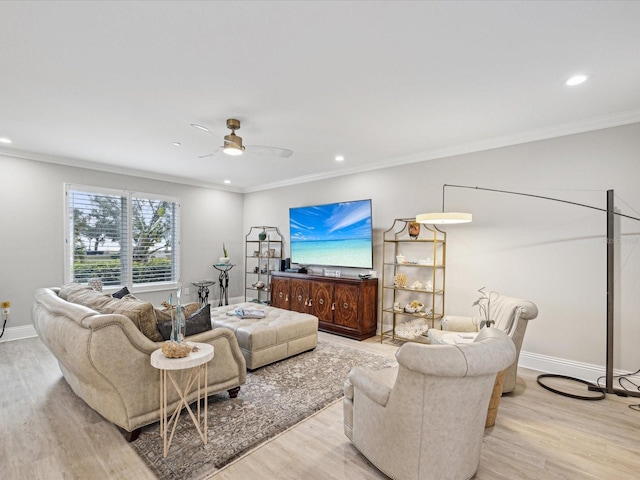 living room featuring ceiling fan, ornamental molding, and light hardwood / wood-style flooring