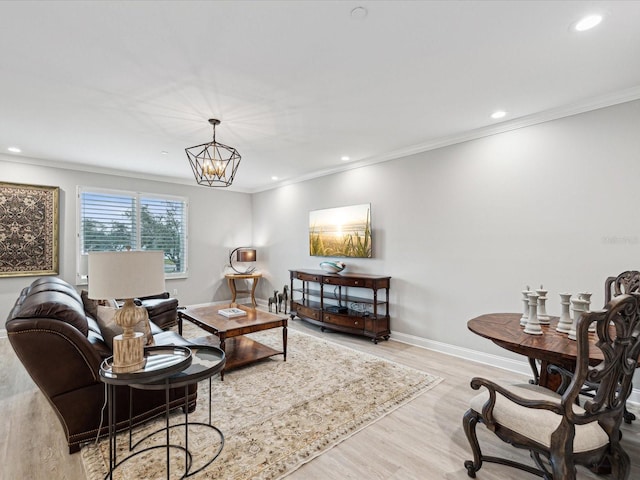 living room featuring a notable chandelier, crown molding, and light hardwood / wood-style floors