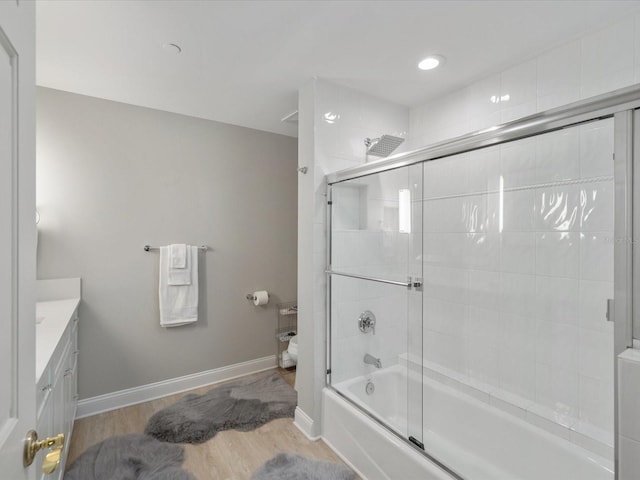 bathroom with vanity, hardwood / wood-style floors, and enclosed tub / shower combo