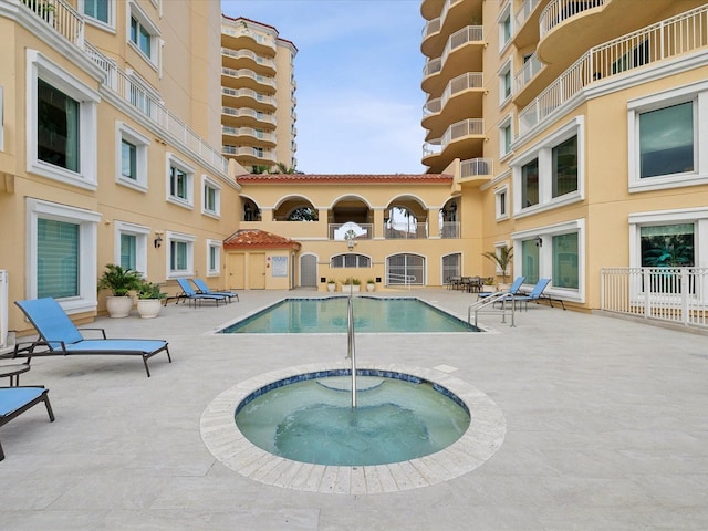 view of pool featuring a community hot tub and a patio