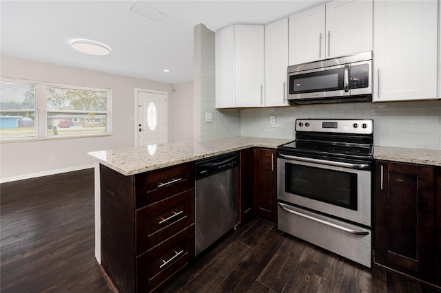 kitchen featuring dark wood-type flooring, kitchen peninsula, white cabinets, and stainless steel appliances