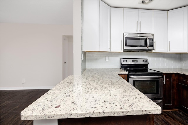 kitchen featuring dark wood-type flooring, backsplash, and appliances with stainless steel finishes