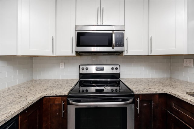 kitchen with appliances with stainless steel finishes, dark brown cabinets, and white cabinetry