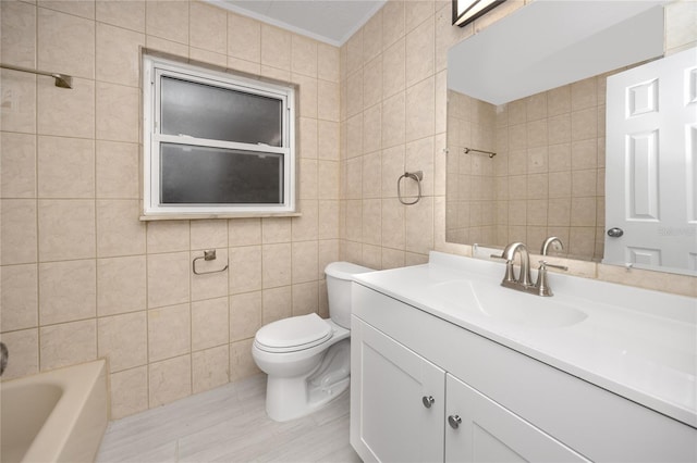 bathroom featuring toilet, vanity, tile walls, and ornamental molding