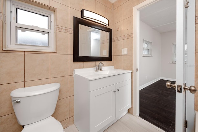 bathroom with tile walls, toilet, and vanity