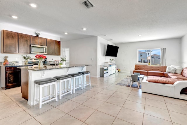 living room featuring a textured ceiling and light tile patterned floors