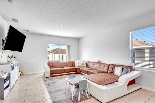 living room with a textured ceiling and light tile patterned floors