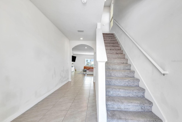 stairway with tile patterned floors