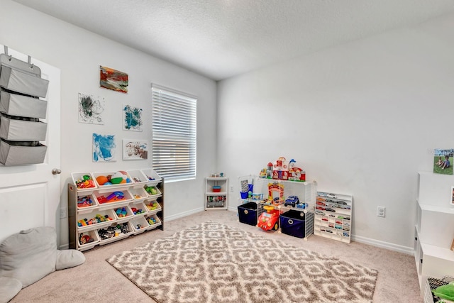 playroom with a textured ceiling and carpet flooring