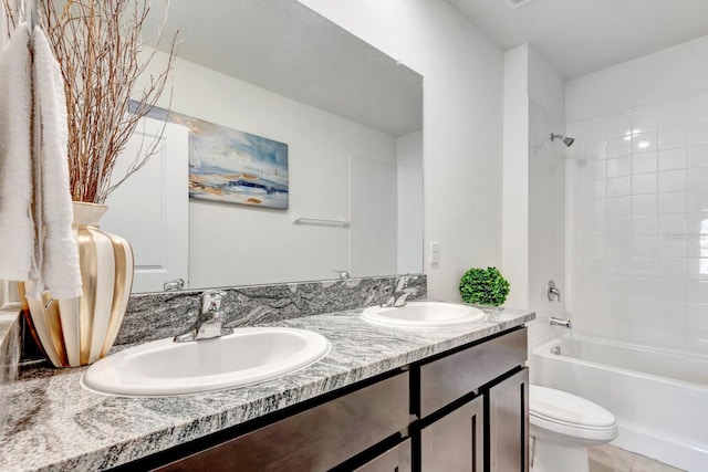 full bathroom featuring toilet, vanity, and tiled shower / bath