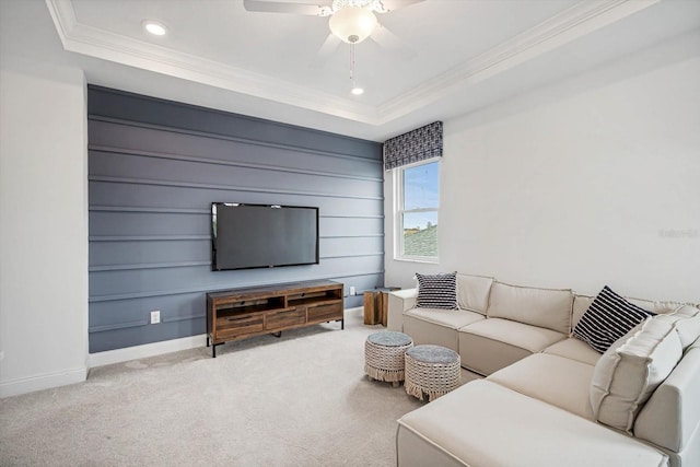 carpeted living room featuring ornamental molding, a raised ceiling, and ceiling fan